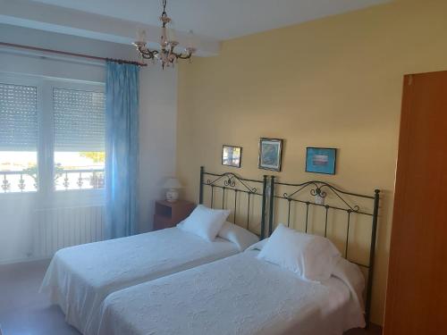 a bedroom with two beds and a window at Pensión Chiquilla in O Grove
