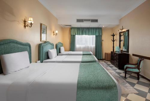 ein Hotelzimmer mit zwei Betten und einem Stuhl in der Unterkunft Holidays Express Hotel Cairo in Kairo