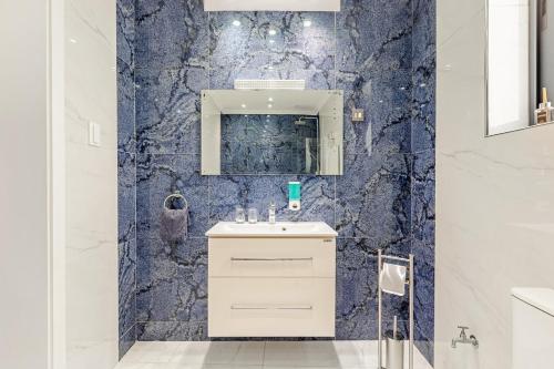 a bathroom with a sink and a blue wall at Azure Apartment in Senglea