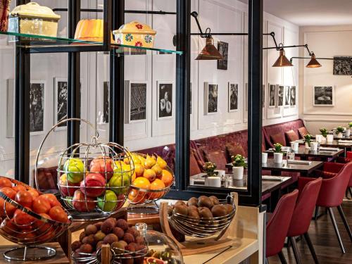 a restaurant with baskets of fruit on a table at Sofitel Strasbourg Grande Ile in Strasbourg