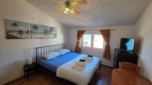 a bedroom with a blue bed and a television at Njofra Banj in Banj