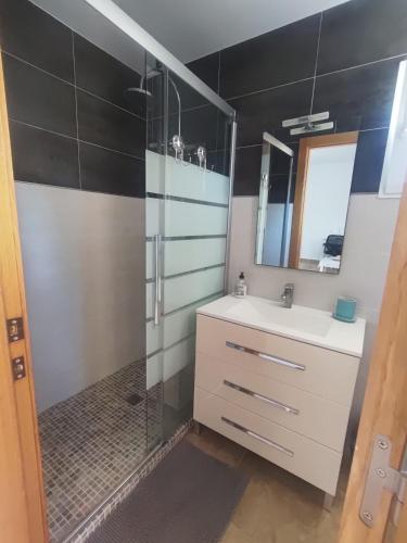 a bathroom with a shower and a sink and a mirror at La pineda in Les tres Cales