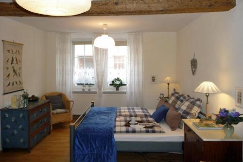 a bedroom with a bed and a couch and windows at Altes Kontor in Bad Sulza