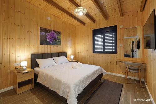 a bedroom with a bed and a desk and a window at Novus Luxury in Yarka
