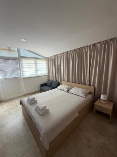 a bedroom with a large bed with white sheets at Apartments La Natalli in Baška