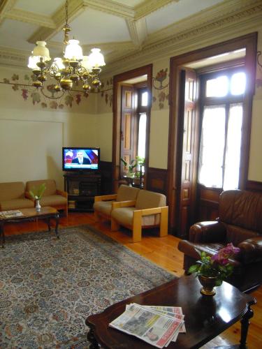 a living room with a couch and a tv at Guesthouse Lusa Atenas in Coimbra