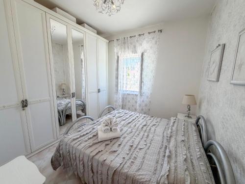 a white bedroom with a bed and a mirror at La Casa di Barbara in Ponza