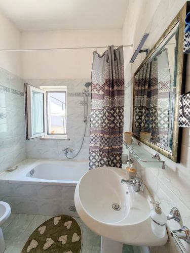 a white bathroom with a sink and a tub at La Casa di Barbara in Ponza