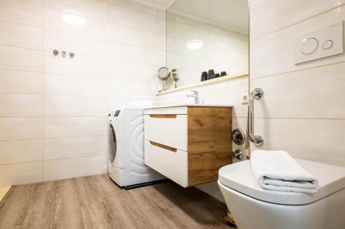 a white bathroom with a toilet and a sink at Exklusive Ferienwohnung am Südstrand mit Meerblick & Balkon Wohnung 10 in Wilhelmshaven