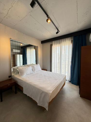 a bedroom with a large bed with a large window at Atlasia Suit in Erdemli