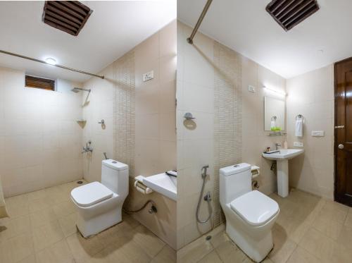 a bathroom with two toilets and a sink at Nook Inn & Suites - 2 Min Walk From MG ROAD METRO in Gurgaon