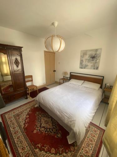 a bedroom with a white bed and a rug at Glen Villa - 3 bedroom house - Stroud town centre in Stroud