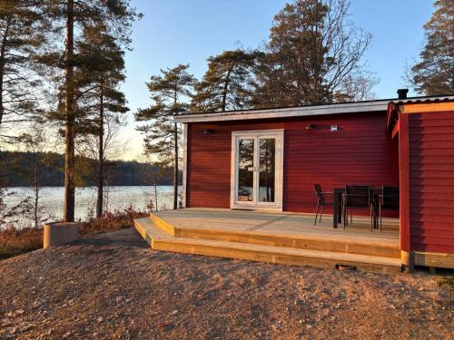 a cabin with a table and chairs on a deck at Långasjönäs Camping & Stugby in Karlshamn