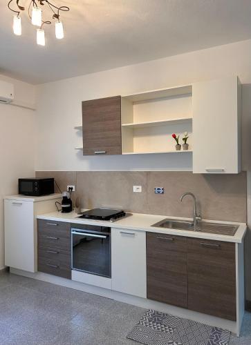 a kitchen with white and brown cabinets and a sink at Màrila in Aggius