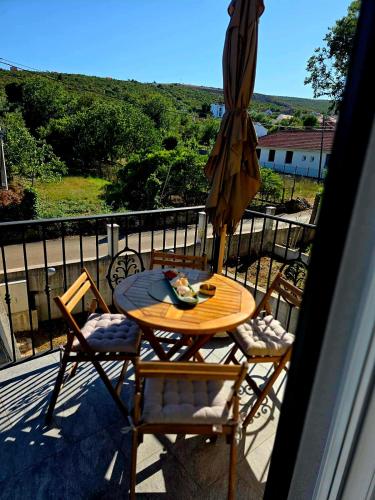 a table and chairs on a balcony with an umbrella at Vila Dara 1924 in Tivat