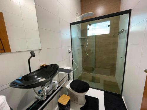 a bathroom with a glass shower and a sink at Recanto das Oliveiras in Corumbau