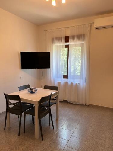 a dining room with a table and chairs and a television at Màrila in Aggius