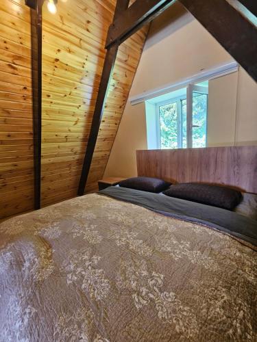 a bedroom with a large bed in a room with wooden walls at Ismayilli in İsmayıllı