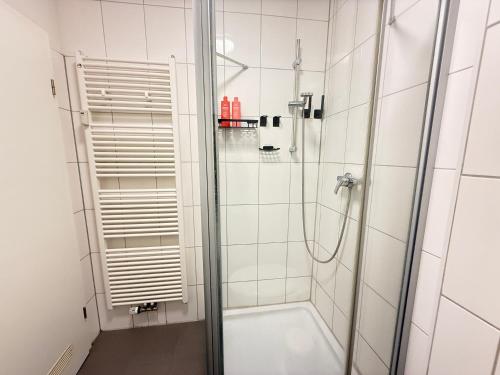 a shower with a glass door in a bathroom at Stage One City in Andernach