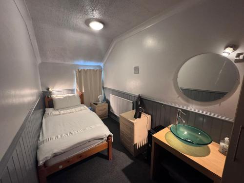 a small room with a bed and a sink at Mallow View Hotel in Cleethorpes