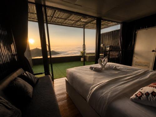 a bedroom with a bed with a view of the ocean at Holiday view ภูทับเบิก in Ban Maeo Thap Boek
