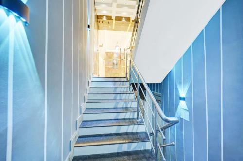 a set of stairs in a building with blue walls at HOTEL O DIVIRA INN in Dhanbād