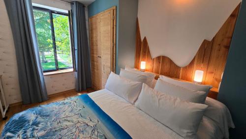 a bedroom with a large bed with a large window at Papillon 05 - Wellness - 6 Pers - Sauna - Jacuzzi - Yoga - Petanque - Parking in Briançon