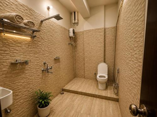 a bathroom with a shower with a toilet and a sink at Hotel Keptown in Patna