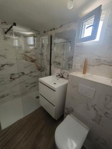 a white bathroom with a toilet and a shower at Mimosas - villa in Fréjus