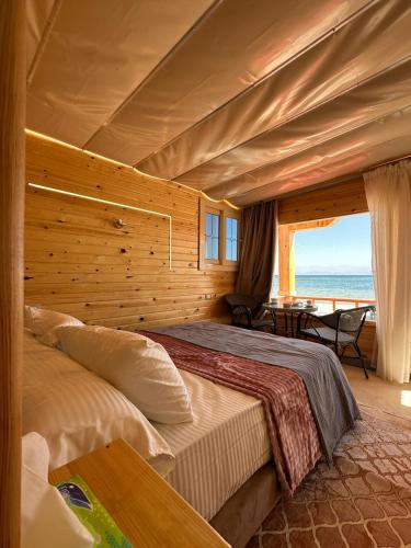 a bedroom with two beds and a view of the ocean at Sondos Camp in Nuweiba‘ el Muzeinah