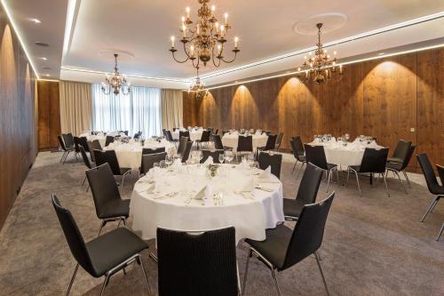 a conference room with tables and chairs and a chandelier at Eden Hotel Wolff in Munich