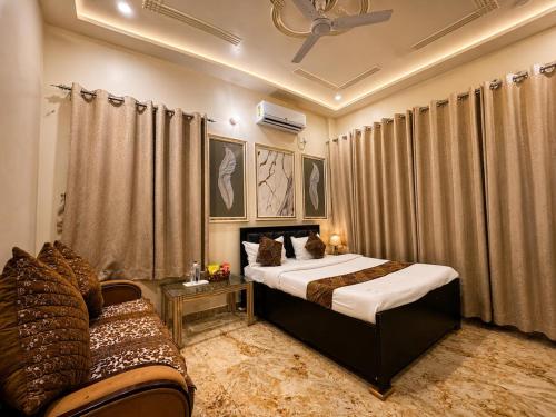 a bedroom with a bed and a couch in a room at Hotel Keptown in Patna