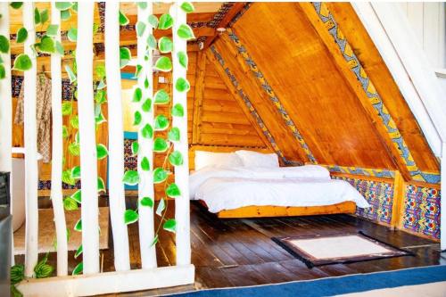 a bedroom in a tree house with a bed at Santorini by Busybee Lake Cabins in Mwanza