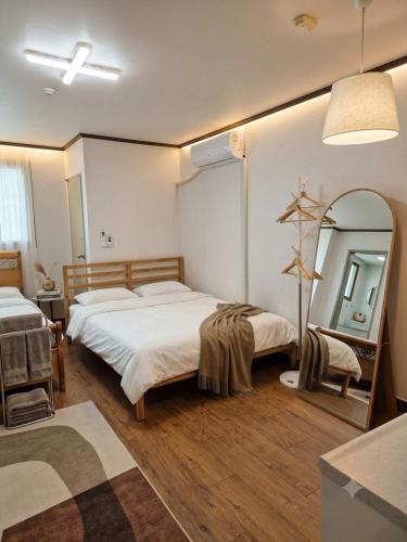 a bedroom with two beds and a large mirror at Seoul Station condo in Seoul