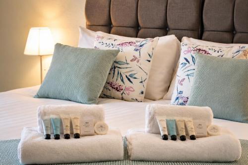 a bed with two towels on top of it at Bridgeside Rooms in Ironbridge