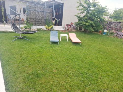 two benches and a chair in a yard at Casa La Bunicu - Curte privata & liniste in Techirghiol