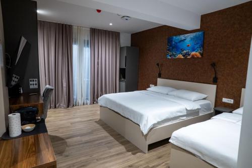 a hotel room with two beds and a desk at Casa sul Mare Luxury Sea View Apartments in Neum