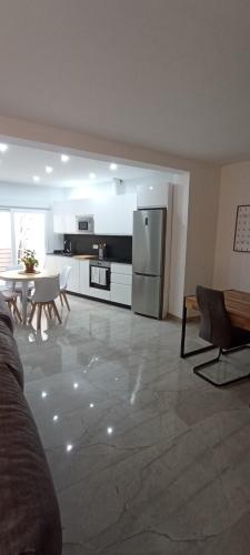 a kitchen with a refrigerator and a table and chairs at Casa Conde in Alfarnate