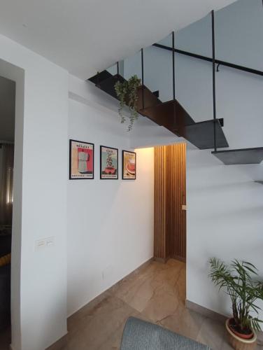 a room with white walls and a staircase and a plant at Casa Conde in Alfarnate