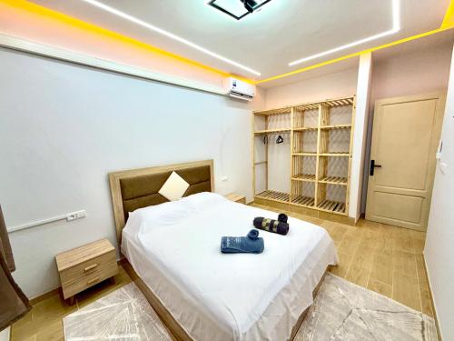a bedroom with a bed with a camera on it at Palm & Tide Kenitra Residence in Kenitra