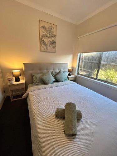 a bedroom with a bed with a stuffed animal on it at Valley View 4BR home near Food trucks and Station in Melton South
