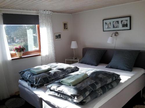 Særslev的住宿－Svalegaarden Guesthouse，卧室配有带枕头的床铺和窗户。