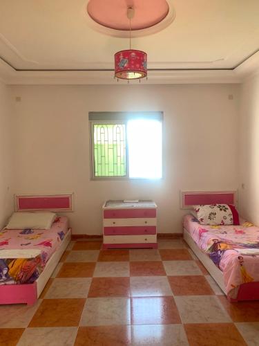 a bedroom with two beds and a window at maison avec jardin in Cabo Negro
