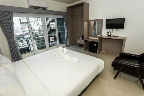 a bedroom with a large white bed and a television at JB Old Town Stay in Ban Lo Long