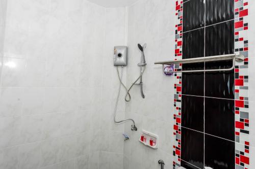 a bathroom with a shower with a phone on the wall at JB Old Town Stay in Ban Lo Long