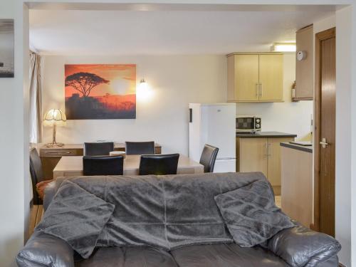 a living room with a couch and a table with chairs at St Abbs Cottage in Belford