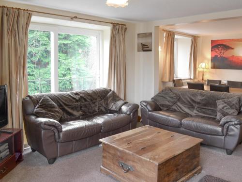 a living room with two leather couches and a coffee table at St Abbs Cottage in Belford