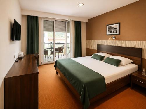 a hotel room with a bed and a balcony at Hotel Oaza in Konjic