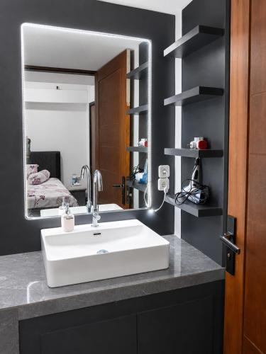 a bathroom with a white sink and a mirror at Villa Droom Nest Manado in Manado