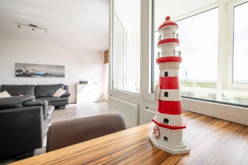 a lighthouse toy sitting on a table in a living room at Komfortable Ferienwohnung für 2 am Südstrand mit Wintergarten & Meerblick Wohnung 12 in Wilhelmshaven